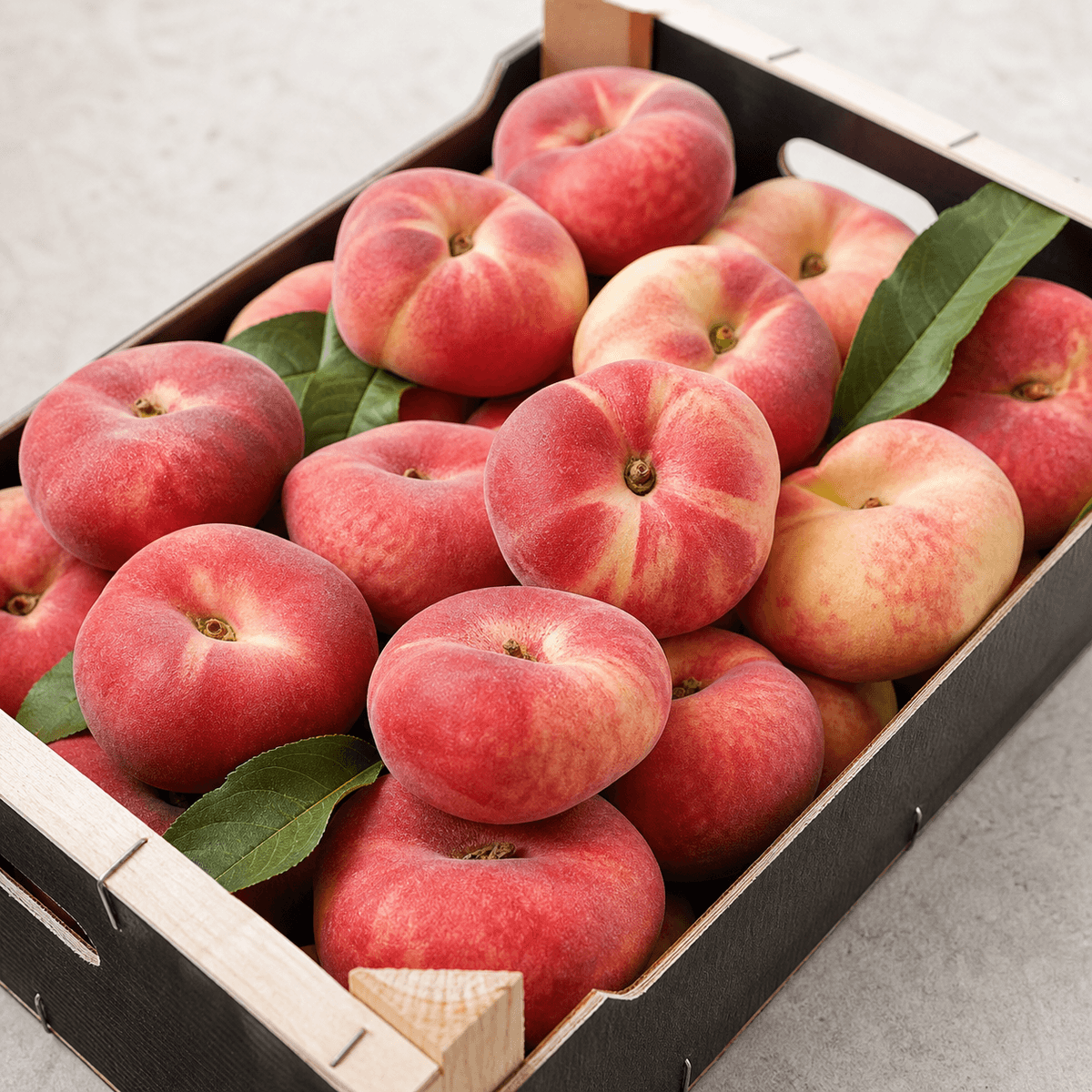 Fresh Spanish flat peaches in a produce crate